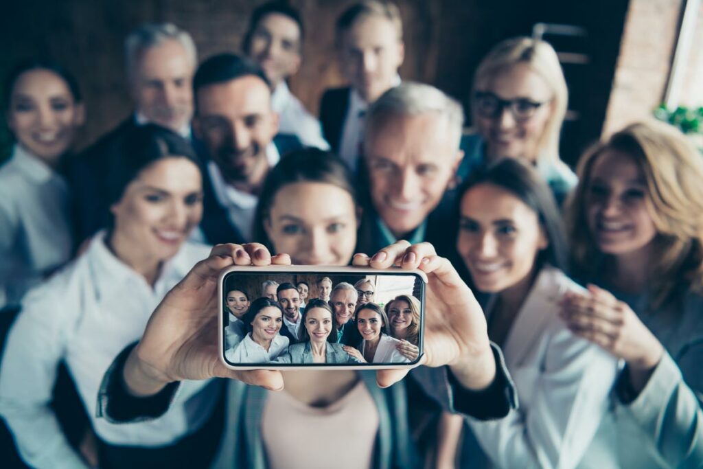 Group of people posing for a photo with a smartphone