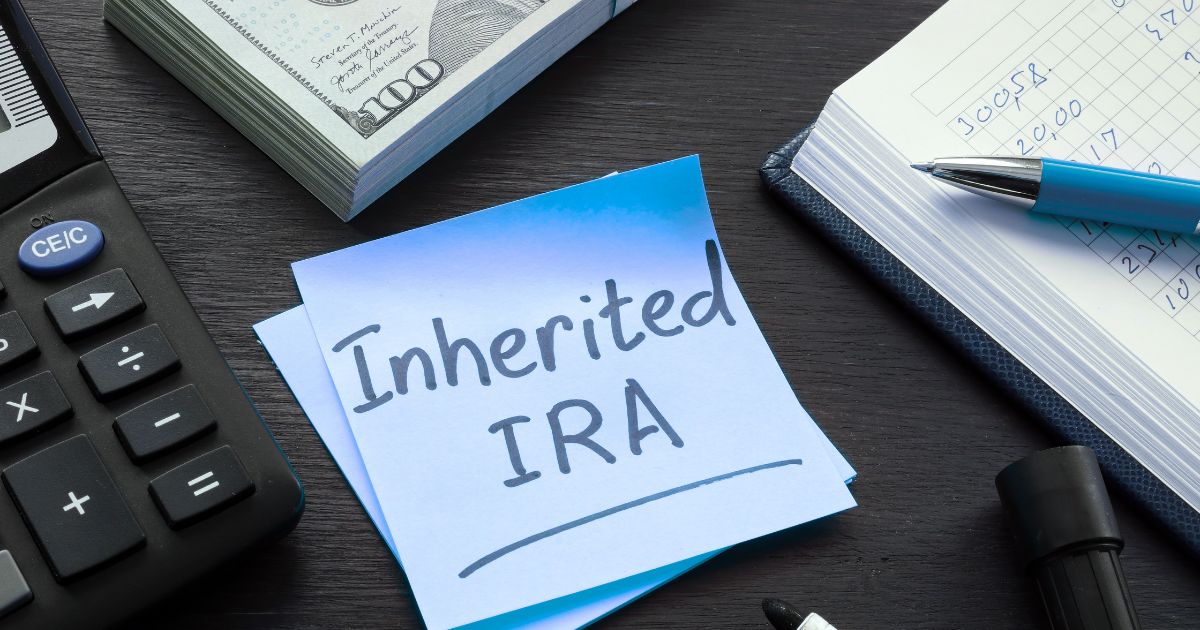 A closeup of a desktop with a post-it note for an article about inherited IRA distribution rules